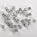 Macro-detail van kubusvormige zilveren kralen met diagonale texturen voor het maken van sieraden - Witgoud Oogpatroon Vierkant (4mm Gat 1,8mm)