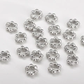 Macro view of flower-shaped spacer beads with cubic zirconia inlays for DIY jewelry - Dot Style / White Gold