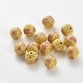 Détail d'une perle creuse émaillée rouge et dorée avec motif ondulé pour bijoux DIY - Rouge