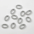 Macro-opname van zilveren gedraaide ovale schakels voor DIY sieraden maken en hobby - Zilver Stijl D Getwist Ovaal (16x11.7mm)