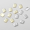 Close-up of Good Luck engraved rectangular metal charms in gold and silver finish - 9*7mm / 14k Gold Square Tag