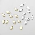 Macro detail of oval gold and silver pendant tags with Red engraving for DIY jewelry - 9.1*5mm / 14k Gold Letter A Tag