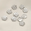 Detailed view of silver flower-shaped metal tags with Hand Made engraving for jewelry - Silver Flower Style