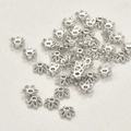 Vista macro di distanziatori a fiocco di neve argentati per la creazione di gioielli - Stile A Cappuccio / Circa 5,1 mm / Bianco K/Argento