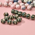 Gros plan de perles en céramique en forme de citrouille avec émaillage et perçage - Perle Citrouille Vert Paon