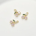 Detailed macro view of cherry fruit charms with pink and green zircon stones on gold base - 1 Piece (Approx 8.2*10.6mm)