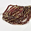 Close-up of 6mm red crystal glass beads with gold spacers for DIY jewelry making - Burgundy