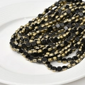 Close-up of 6mm flat round crystal glass beads with gold plated edges for DIY jewelry crafts - Black