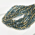 Macro detail of 6mm blue crystal glass beads with gold plated edges for DIY jewelry making - Lake Blue
