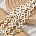 Vue macro de perles à fleurs vintage crème avec veines sombres sur un plateau en bois - Style Fleur à Quatre Feuilles (28#)