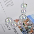 Macro shot of iridescent aurora borealis glass beads with high transparency for DIY jewelry - 14mm