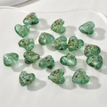 Makroaufnahme von 15mm grünen Herzperlen aus Glas mit bunten Folienflocken für Schmuck - 1 Stück / Malachitgrün