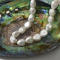 Baroque irregular white pearl necklace displayed inside a natural abalone shell background - 11# Baroque Irregular Shell Bead / Approx. 9.5*11.3mm