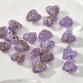 Dettaglio macro di perline a cuore viola 15mm con glitter per creazione di gioielli DIY - 1 Pezzo / Viola