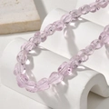 Primo piano di perle di vetro viola chiaro con texture a coste per gioielli fai-da-te - Forma Irregolare Rosa