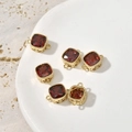 Detailed macro view of five red square zircon pendants with 14k gold plated metal frames - Red