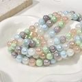 Close-up of 8mm iridescent macaron glass beads with aurora pearl finish for DIY jewelry - Pink Blue Mixed