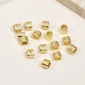 Dettaglio macro di perline cilindriche placcate oro 14k con micro-intarsio in zircone H - Numero 1 6.5*5.2mm