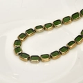 Gros plan de perles rectangulaires en verre de cristal vert avec bordures dorées - Vert Herbe