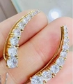 Handheld view of gold-plated curved ear climbers with shimmering round cubic zirconia stones - Large / Large-Gold
