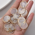 Vue détaillée de pendentifs ronds en nacre naturelle avec bordure dorée pour bijoux DIY - 20mm