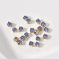 Vista macro de cuentas espaciadoras de circón azul con engaste de cuatro garras doradas - Azul Oscuro (17# 4x4mm)