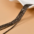 Dettaglio macro di perline a cubo in ematite da 2mm per creazione gioielli DIY - caffè