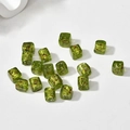 Vue macro de perles carrées en verre vert avec feuilles d'or pour la création de bijoux - Cube Vert Fruit