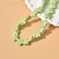 Detail of light green ceramic flower beads for DIY necklace with glossy glazed texture - Green