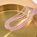 Rosafarbene 2mm facettierte Katzenaugen-Perlen für DIY-Schmuck auf einem Goldtablett - Hellrosa