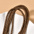 Detailed view of bronze disc-shaped hematite spacers arranged on a white ceramic shell - 260 Pieces/Pack / Bronze Wave Spacer
