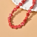 Macro detail of red five-petal ceramic flower beads for DIY jewelry making - Red