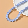 Detailed close-up of light blue ceramic flower beads for DIY jewelry making and crafts - Blue