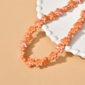 Macro shot of orange five-petal floral ceramic beads with a pearlescent glaze finish - Orange Red