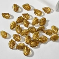 Vista macro di perline di vetro ritorte color ambra oro con foglia d'oro per gioielli DIY - Oro Ambra
