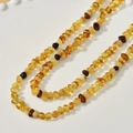 Macro detail of irregular amber and beeswax stone beads on a white ceramic plate - Irregular Amber Baby Chain Style (24#4*6mm)