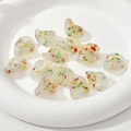 Dettaglio macro di perline in vetro a forma di virgola con macchie colorate a olio - Polvere d'Oro Giada Punti Colorati