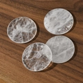 Close-up of four natural white quartz discs with ice crack textures on wood background - White Crystal