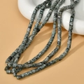 Macro detail of 4x4mm cylindrical natural stone beads with spotted texture on white ceramic - Cylindrical Style (4#) / 4*4mm (Approx. 95 Beads/Strand) / Green Moss Stone