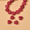 Macro shot of polished red heart-shaped natural stone beads for DIY jewelry making - Red Heart