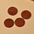 Close-up of four round polished red jasper stone pendants with natural dark veins - Red Jasper