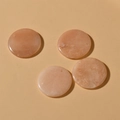 Close-up of four polished 30mm natural orange-pink gemstones with pre-drilled holes for DIY jewelry - Pink Aventurine