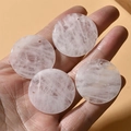 Close-up of four natural rose quartz round gemstone discs with pre-drilled holes for DIY - Rose Quartz