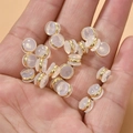 Close-up of 18k gold plated silicone earring backs held in palm for DIY jewelry making - 7mm Gold