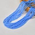 Close-up of 3mm blue faceted glass macaron beads on a stylish yellow ceramic tray - Lake Blue (18#)