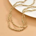 Close-up of gold-plated faceted hematite beads on a ceramic plate for DIY jewelry - Matte KC Gold Faceted (3mm)