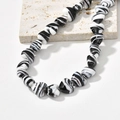 Detailed view of heart-shaped glass beads with black and white marble swirl texture - Black Heart