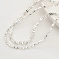 Close-up of irregular silver metallic beads on a textured surface for jewelry making - Design No.4 / 4x3mm / Silver