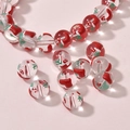 Close-up of glass Christmas beads with red stocking and white snowflake patterns for DIY jewelry - Christmas Sock Round Bead