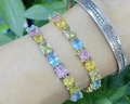 Bunte Zirkonia-Tennisarmbänder in Gold und Silber am Arm getragen im Freien - Armband / Gold